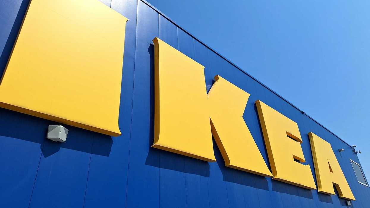 Yellow IKEA signage on a blue building against a blue sky.